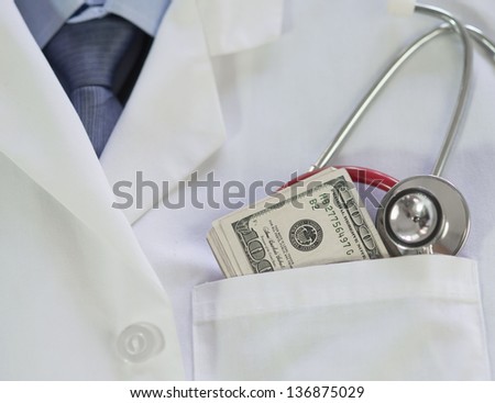 A Doctors stethoscope and one hundred dollar bills used to illustrate the expense of medical care
