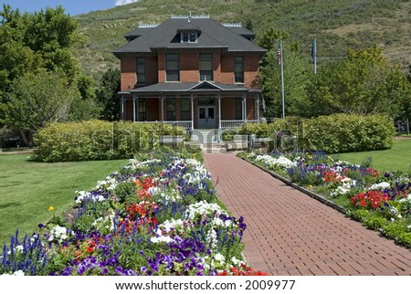 old style library or hospital, or home with brick walkway and flowers and landscaping