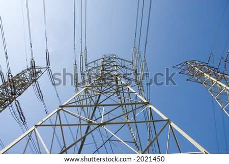 a group of high voltage power towers and electrical lines going over a hill from the power station