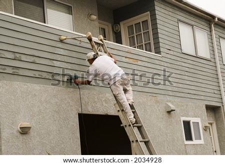man on a ladder doing home repair