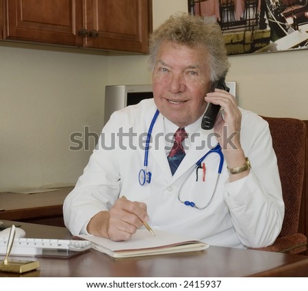 Doctor sitting at his desk and talking on the telephone