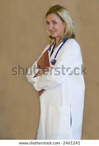 attractive female doctor stands with folded arms and charts