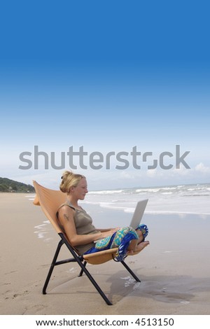 attractive young woman with notebook computer at the beach