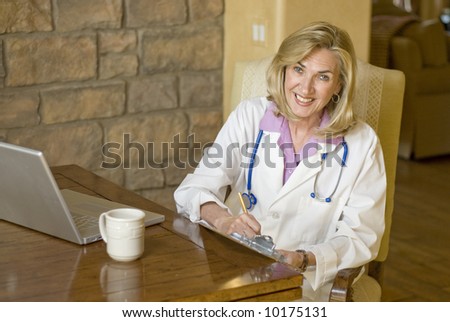 attractive female doctor sitting down and writing