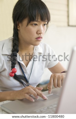 attractive young asian girl working on computer