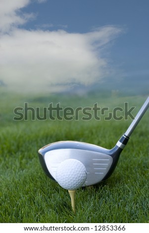 golf club and golf ball on green grass with blue sky