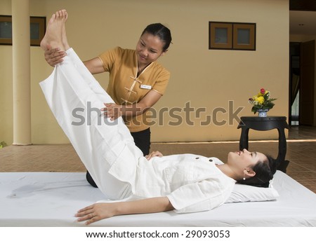 Woman getting Thai massage from professional masseuse