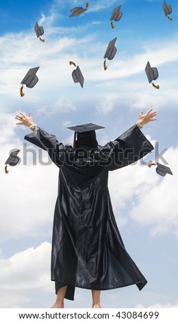 woman in graduation gown with her hands in the air