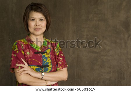 Portrait of successful middle aged Asian woman with her arms crossed
