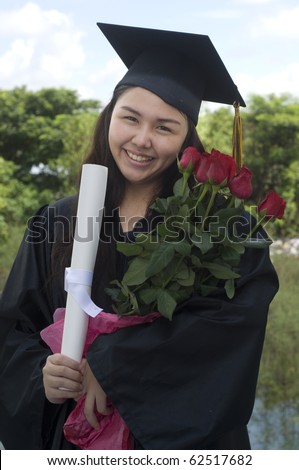Young woman with graduation cap and gown holding Roses