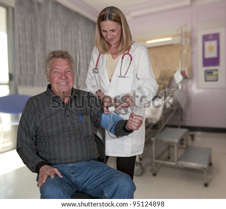 Woman Doctor checking elderly patients blood pressure