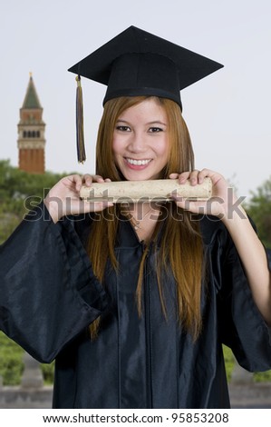 Young woman with graduation cap and gown holding diploma