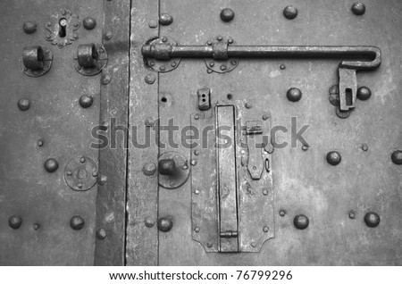 Part of old ancient metal door with broken lock.