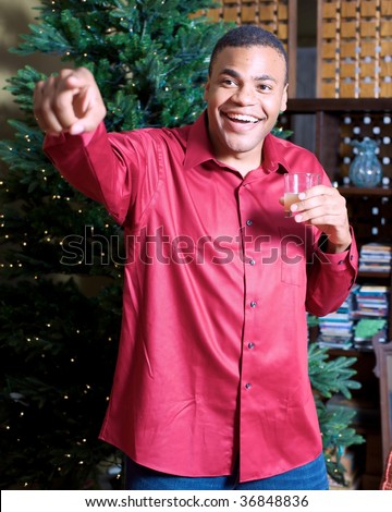 Young Man in Front of Christmas Tree Points