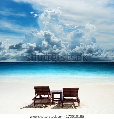 Relaxing on remote beach with raining cloud