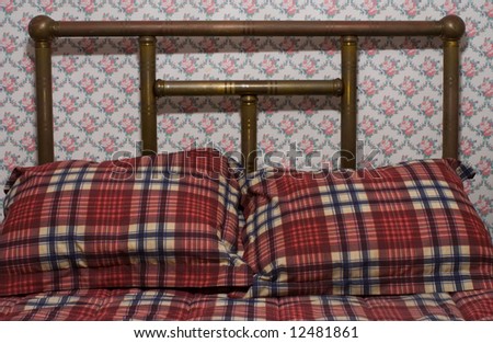 Detail view of head of antique brass bed and bedclothes.