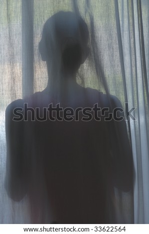 Female standing behind thin curtain, back towards camera.