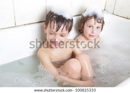 two smiling children having bath