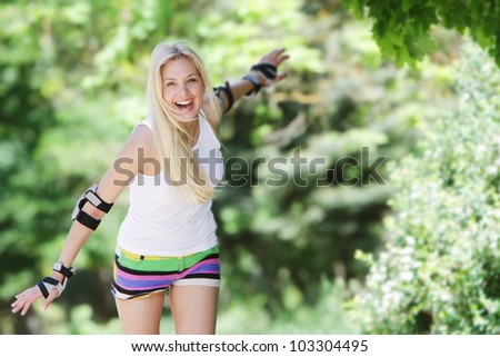 Rollerblade / roller skating woman going skating on inline roller blades. Young happy girl enjoying outdoor workout