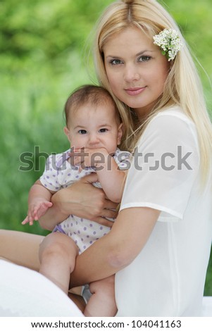 young happy mother and baby on natural background