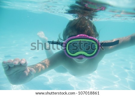 underwater portrait of young child diving in mask