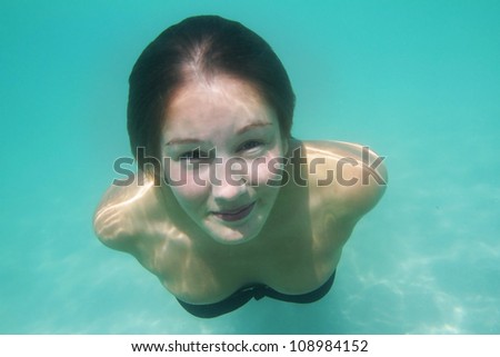 young woman swimming underwater in sea or pool