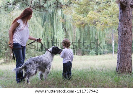 young happy family - mother and child - with dog on natural background