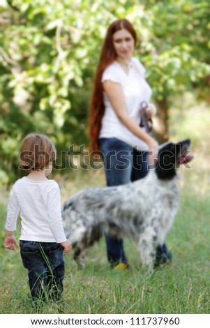 young happy family - mother and child - with dog on natural background