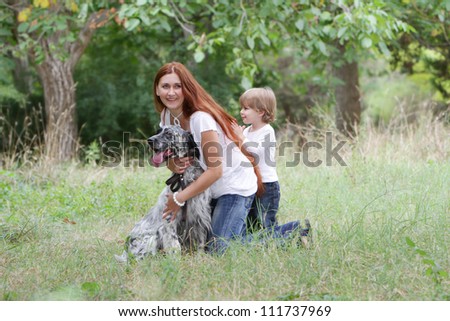 young happy family - mother and child - playing with dog on natural background