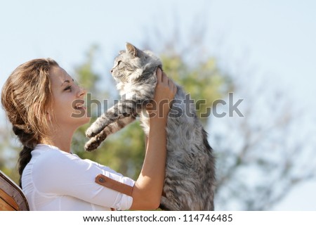 young happy smiling woman with cat on natural background