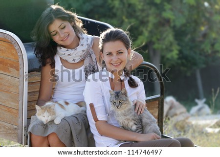young happy smiling women with cats on natural background