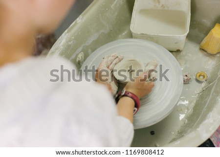 working with clay on potter\'s wheel, closeup of hands, crafts and arts
