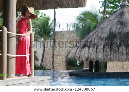young beautiful woman in hat relaxing near pool
