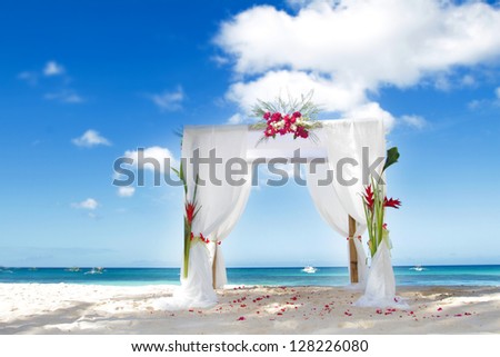 wedding arch decorated with flowers on beach