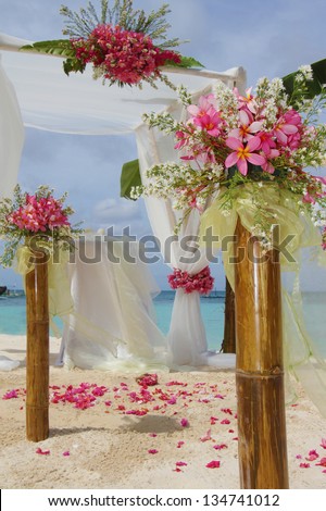 wedding arch and set up with flowers on tropical beach