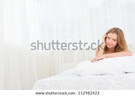 indoor portrait of young caucasian woman sleeping or awaken in bed at home