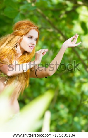 young beautiful woman in traditional arabic clothes, belly-dancer on natural background