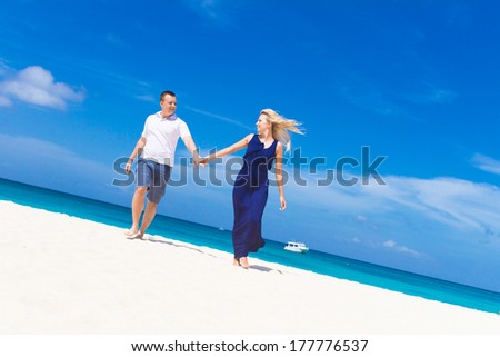 young happy loving couple on tropical sea and sky background