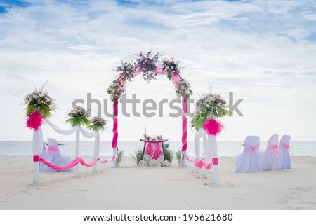 wedding arch decorated with flowers on beach