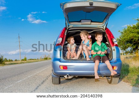 three happy kids in car, family trip, summer vacation travel