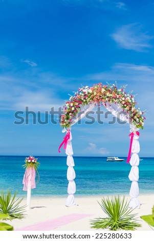wedding arch, cabana, gazebo on tropical beach decorated with flowers, beach wedding decoration
