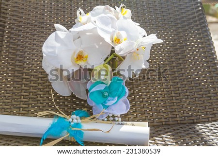 beautiful wedding bouquet from white orchids and wedding certificate on natural background