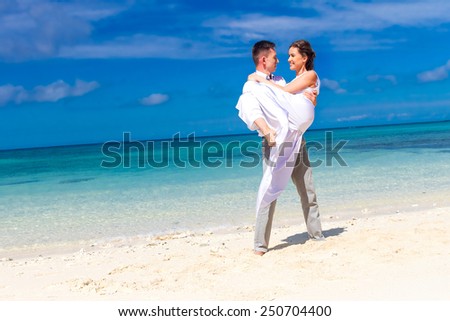 young loving couple on their wedding day, outdoor beach wedding in tropics