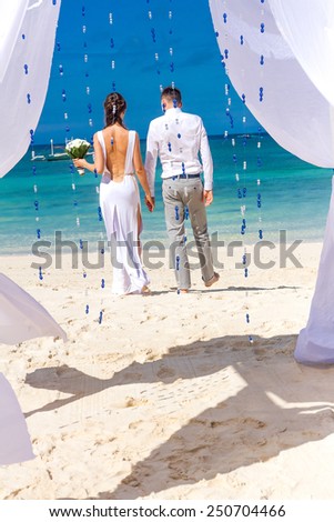 young loving couple on their wedding day, outdoor beach wedding in tropics