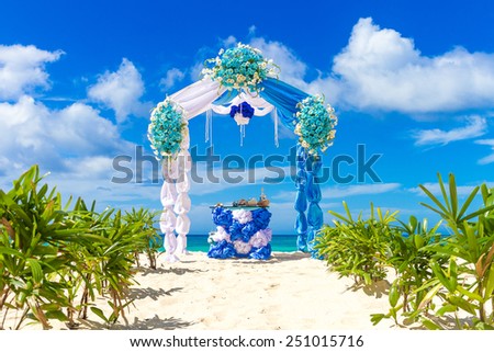 beautiful decorated wedding arch on sand beach, outdoor tropical wedding setup and venue