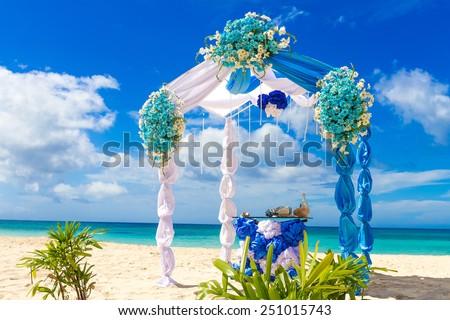 beautiful decorated wedding arch on sand beach, outdoor tropical wedding setup and venue
