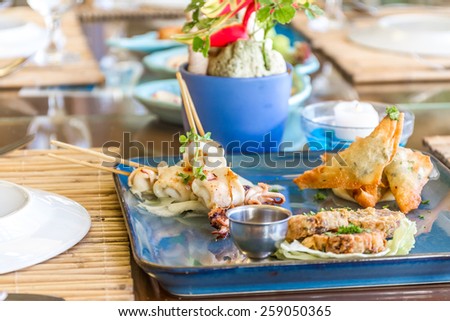 seafood snacks, calamaris, squid rings served in outdoor restaurant, asian cuisine
