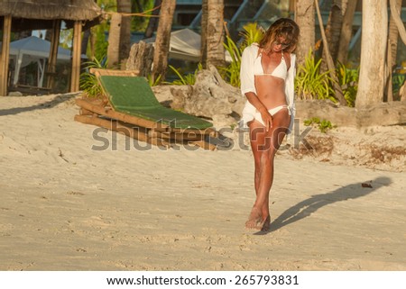 young happy beautiful woman enjoying summer vacation on tropical sand beach, sunbathing, outdoor portrait