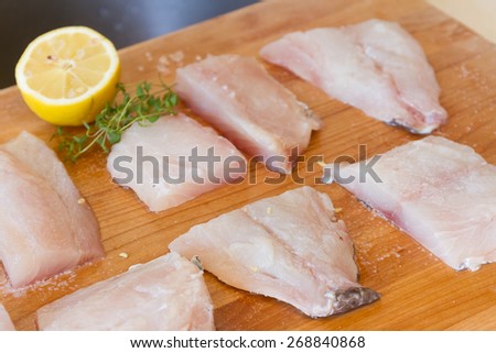fresh fish on wooden cutting board ready for cooking