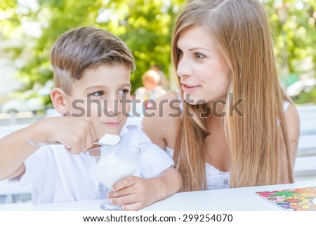 mother and child - boy - enjoying meal time in street cafe, restaurant, family time, lunch in outdoor restaurant